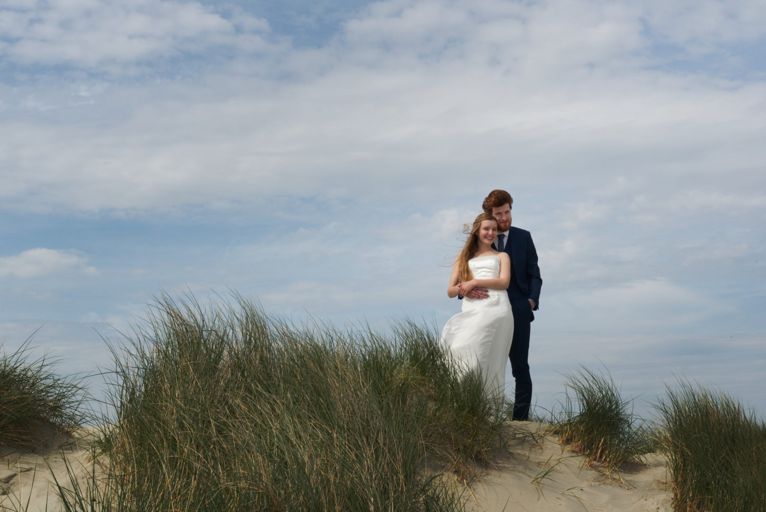 Logo elements ARROWS copyright Nadina Bee outdoor wedding law change England and Wales, wedding couple hugging in the sand dunes on a sunny day for