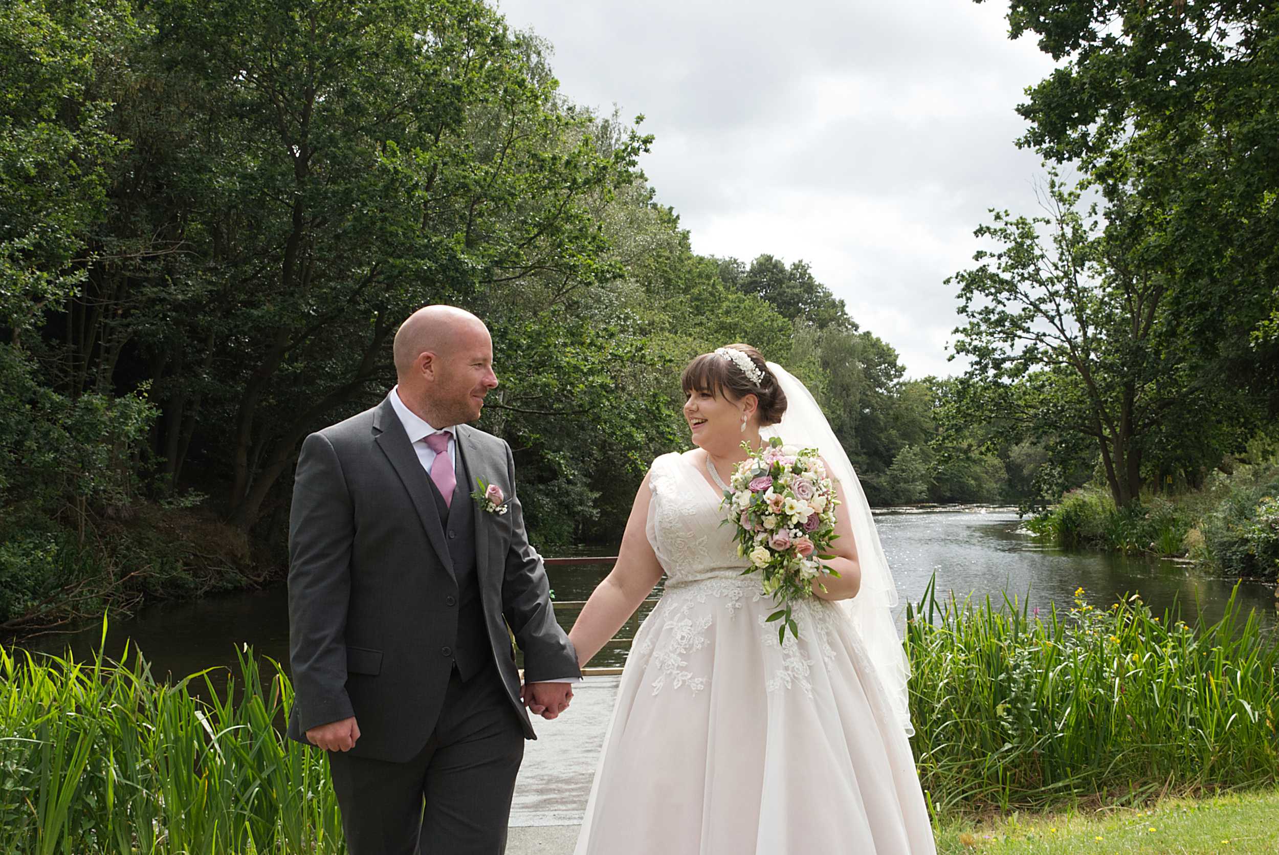 candid handfasting photography of happy couple walking by the lake of stoke place