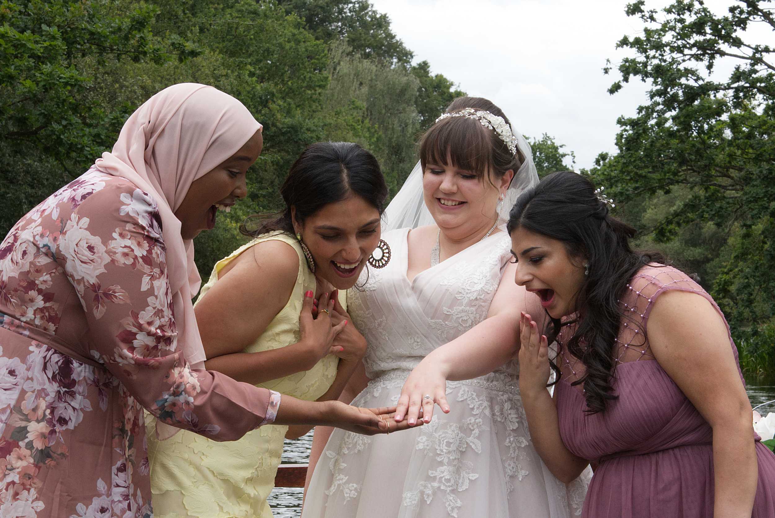 bridesmaids admiring bride's wedding ring silly wedding photo